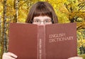 Girl looks over English Dictionary Royalty Free Stock Photo