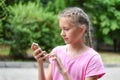 Girl looks into the phone outside. online communication. internet addiction