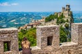 Girl looks at San Marino, Guaita, first of three peaks which overlooks the city