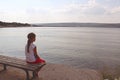 Girl looks at the sea sitting on a bench on the beach Royalty Free Stock Photo