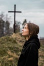 The girl looks into the sky against the background of the cross. Faith in God. Hope in God Royalty Free Stock Photo