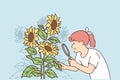 Girl looks at sunflowers through magnifying glass, wishing to become farmer or botanist