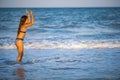 A girl with loose hair walks on the sea with waves and enjoys the sun Royalty Free Stock Photo