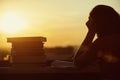 Girl with a lot of books on sunset background. Preparation for university exams. education concept Royalty Free Stock Photo