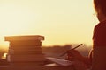 Girl with a lot of books on sunset background. Preparation for university exams. education concept Royalty Free Stock Photo