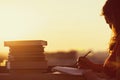 Girl with a lot of books on sunset background. Preparation for university exams. education concept Royalty Free Stock Photo