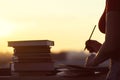 Girl with a lot of books on sunset background. Preparation for university exams. education concept Royalty Free Stock Photo