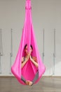 Girl lotus pose aerial antigravity yoga. Woman sits in hammock Royalty Free Stock Photo