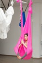 Girl lotus pose aerial antigravity yoga. Woman sits in hammock Royalty Free Stock Photo