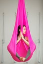 Girl lotus pose aerial antigravity yoga. Woman sits in hammock Royalty Free Stock Photo