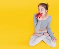 Girl in lotus pose eating apple