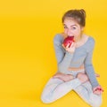 Girl in lotus pose eating apple