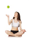 Girl in the lotus position throws apple