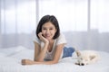 A girl lounging with a white Shiba Inu on the bed in the bedroom. Hokkaido inu dog with young woman Royalty Free Stock Photo