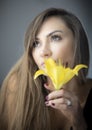 Girl in love, young and fit , beautiful woman with a yellow flower - daffodil. Romantic pose.