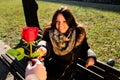 Girl lovingly looking at the hand and a red rose Royalty Free Stock Photo