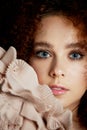 A girl with lush curly red hair. Delicate makeup with false eyelashes in doll style. Ruches cream color. Royalty Free Stock Photo