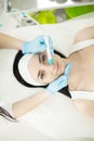 Girl lying in beauty spa enjoying skin therapy using current treatment Royalty Free Stock Photo