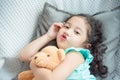 Girl lying on bed and doing funny face at camera