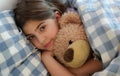 Girl Lying in Bed Hugging Her Teddybear Royalty Free Stock Photo