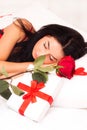 Girl lying in bed, strewn with hearts and roses Royalty Free Stock Photo