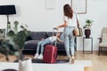 Girl lying on the couch, her mother standing with a suitcase. Travel, lodging