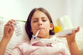 Girl lying on the couch with a thermometer in her mouth Royalty Free Stock Photo