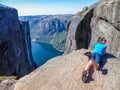 Norway - A girl lying at the edge of a steep mountain, pretending to be flying