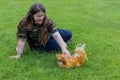 Girl lying on the grass with a cute padovana chicken
