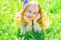 Girl lying on grass at grassplot, green background. Girl on dreamy face spend leisure outdoors. Heyday concept. Child