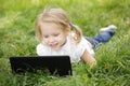 Girl lying on the grass with laptop Royalty Free Stock Photo