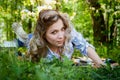Girl lying on the grass in the park with flowering Apple trees in a spring time Royalty Free Stock Photo