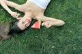 Girl lying on the grass with a slice of watermelon