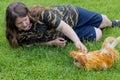 Girl lying on the grass with a cute padovana chicken.