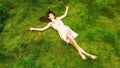 Girl lying on a green meadow. Drone aero shot