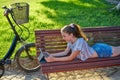 Girl lying on park bench playing with tablet Royalty Free Stock Photo