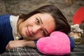 Girl lying with pink plush heart