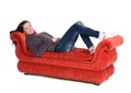 Girl lying on a red sofa isolated on white Royalty Free Stock Photo