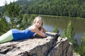 Girl lying on a rock and enjoying river view