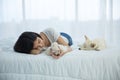 A girl lying in a room with a white Shiba inu dogs and maltese dog