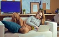 Girl lying on a sofa looking at a laptop. The girl lies on the devan and watches TV shows, videos, procrastination Royalty Free Stock Photo