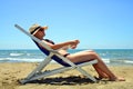 Girl lying on a sun lounger on sandy beach. Royalty Free Stock Photo