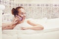 The girl is lying in the whirlpool with foam and talking on a waterproof phone. The girl relaxes and gossips. Royalty Free Stock Photo