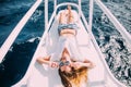 Girl lying on yacht deck. Smiling lady in swimsuit. Relax and enjoy your vacation. Royalty Free Stock Photo