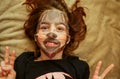 Girl made a face mask. Girl 9 years old or 10 years old. Facial care in joy. The girl made a cellulose mask