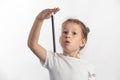 Girl magician with a magic wand in her hands - young magician performing with a magic wand - against white background