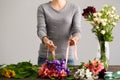 Girl make bouquet over gray background.