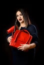 Girl make-up artist in dark dress with red suitcase and accessorized make-up artist