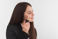 Girl, make-up artist, with long dark hair in a business suit, applies a concealer on the face on a white background Royalty Free Stock Photo