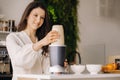 a girl makes a cocktail in a fruit blender in the kitchen. Diet for weight loss